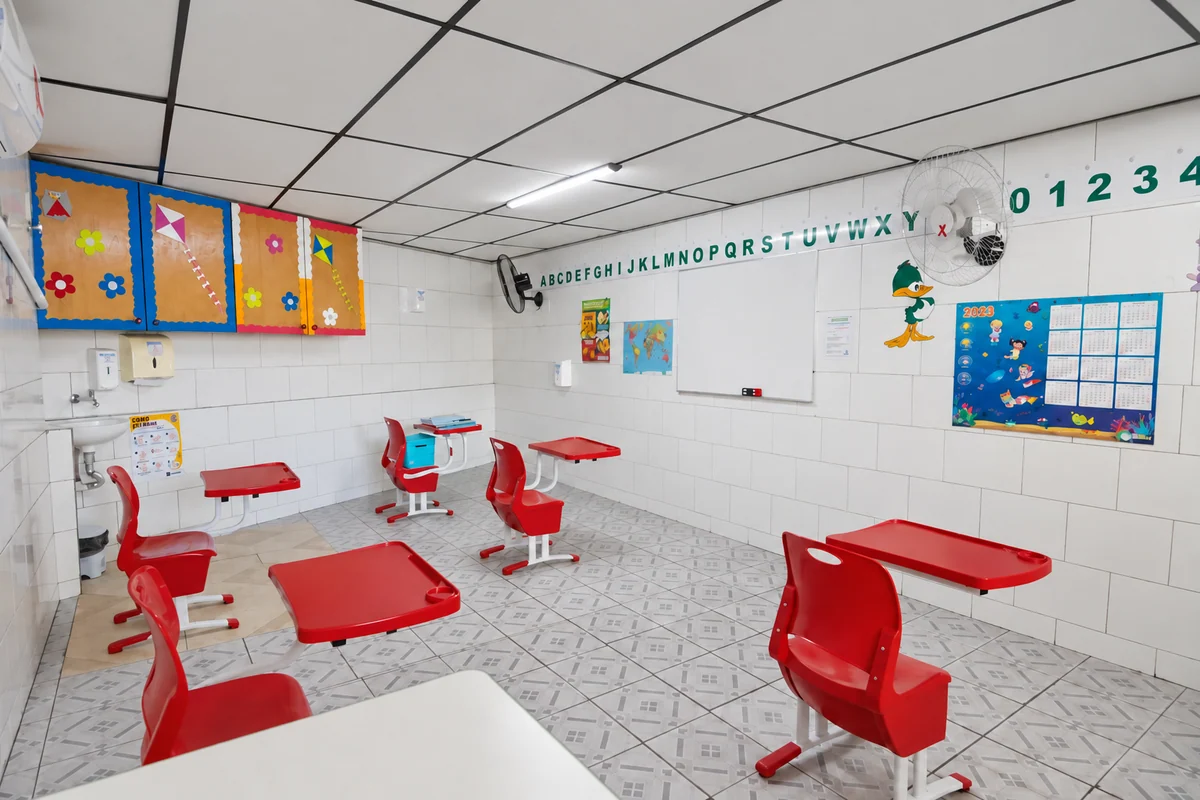 Sala de aula do Ensino Fundamental com carteiras e materiais pedagógicos